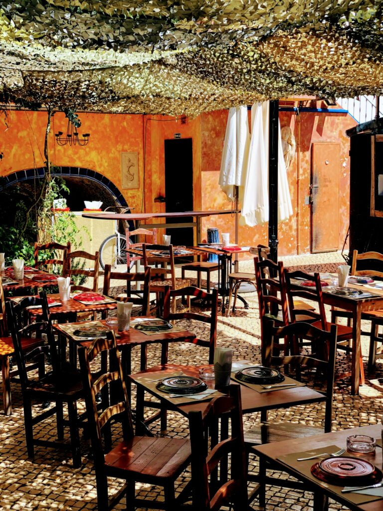 Terrasse typique d’un café marocain sous ombrage, ambiance authentique des Cafés et Salons de Thé au Maroc