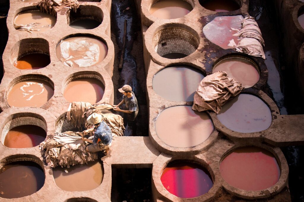 Vue plongeante sur la tannerie Chouara à Fès, Maroc, avec ses cuves colorées et les bâtiments environnants.