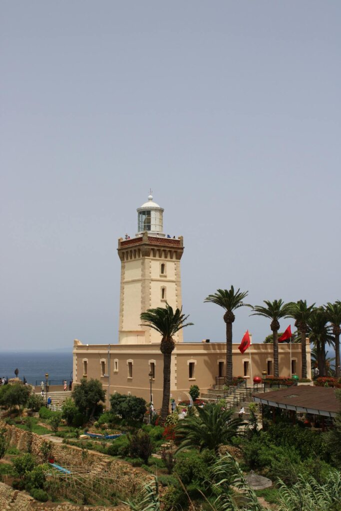 Vue du phare du Cap Spartel, un point de repère important près de Tanger, au Maroc, entouré de palmiers et de jardins.