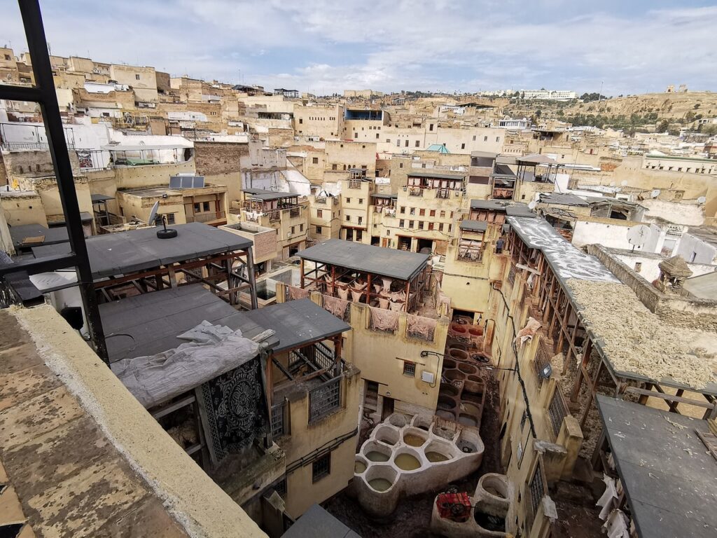 Vue plongeante sur la tannerie Chouara à Fès, Maroc, avec ses cuves colorées et les bâtiments environnants.