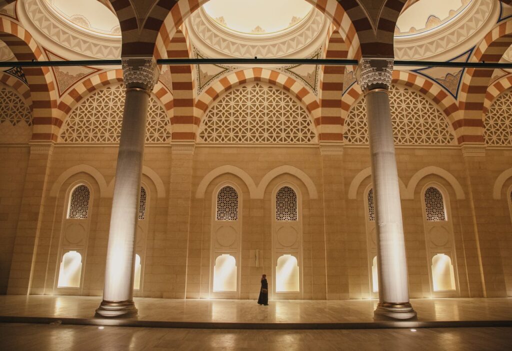 Intérieur majestueux d’un édifice arabo-andalou à Fès, illuminé par une lumière dorée, une scène évoquant l’atmosphère spirituelle du Festival de Fès des Sagesses du Monde.