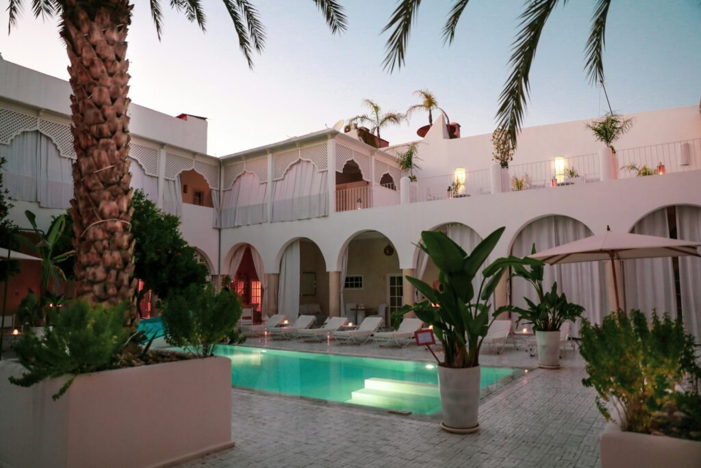 Riad traditionnel avec piscine et patio arboré, hebergement au Maroc offrant calme, confort et authenticité.