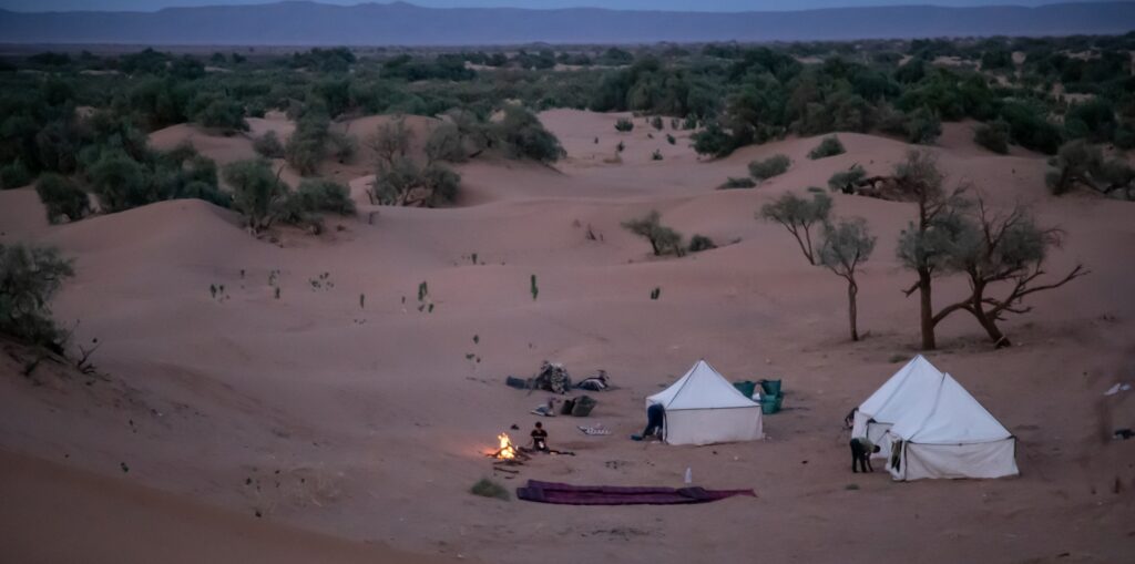 Campement nomade paisible installé au pied des dunes de sable lors d'une Retraite dans le Désert Marocain.