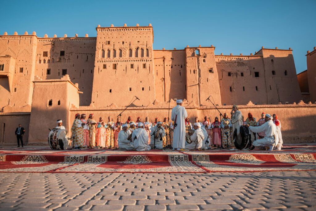 Une vue d'ensemble captivante lors de l'un des festivals de musique au Maroc, se déroulant sur une grande place en briques, devant un imposant et majestueux kasbah berbère aux murs de terre crue.