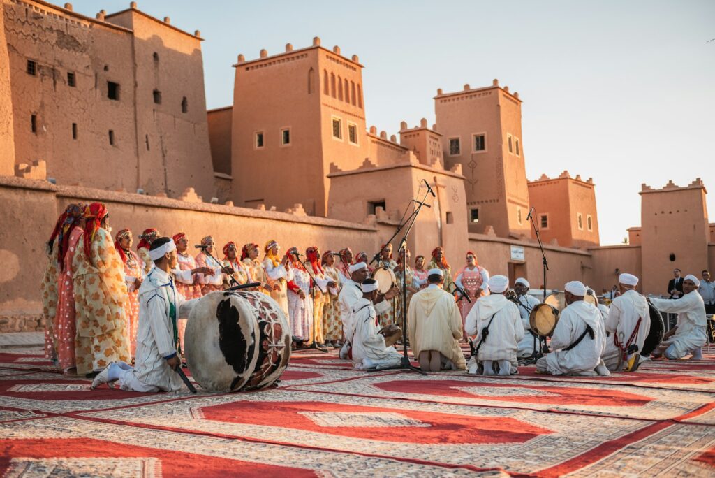 Une performance animée en plein air au Kasbah Aït Benhaddou, mettant en scène un grand ensemble de musiciens et de chanteurs berbères traditionnels lors de l'un des festivals de musique au Maroc.