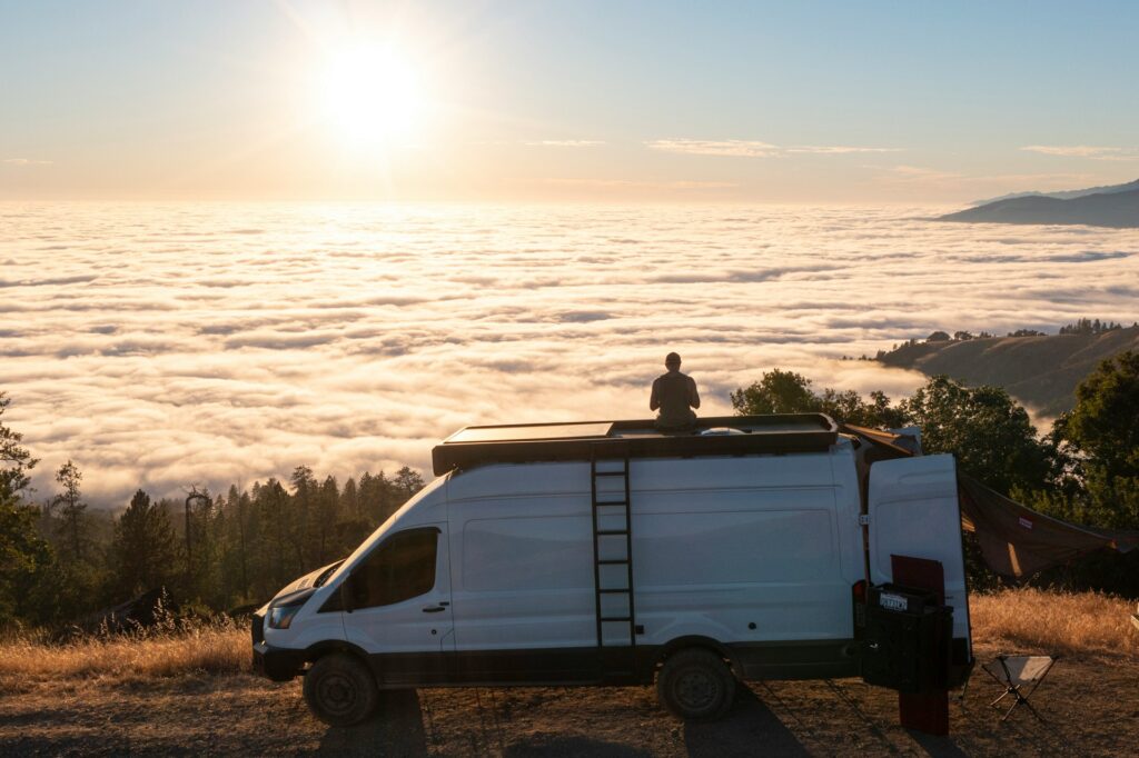 Un camping-car installé face à un paysage spectaculaire au lever du soleil, offrant une scène qui évoque parfaitement la liberté du voyage. Cette image illustre l’esprit du Maroc en camping-car.