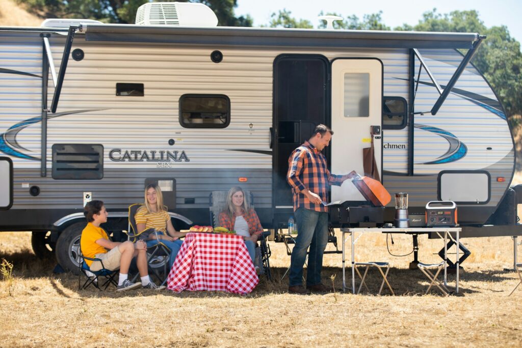 Une famille profite d’une pause conviviale, autour d’un barbecue, parents et enfants savourent un moment de détente. Une des activités à faire lors d’un road trip familial au Maroc.